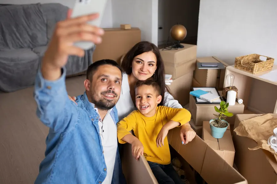 Família entre caixas de mudança, tirando uma selfie
