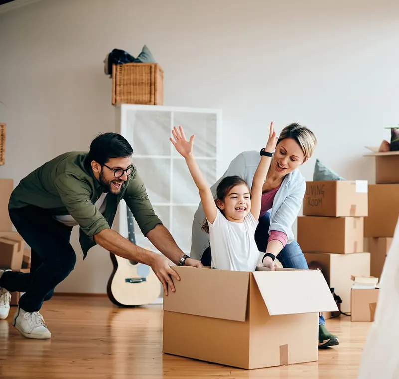 Família brincando entre caixas em casa nova